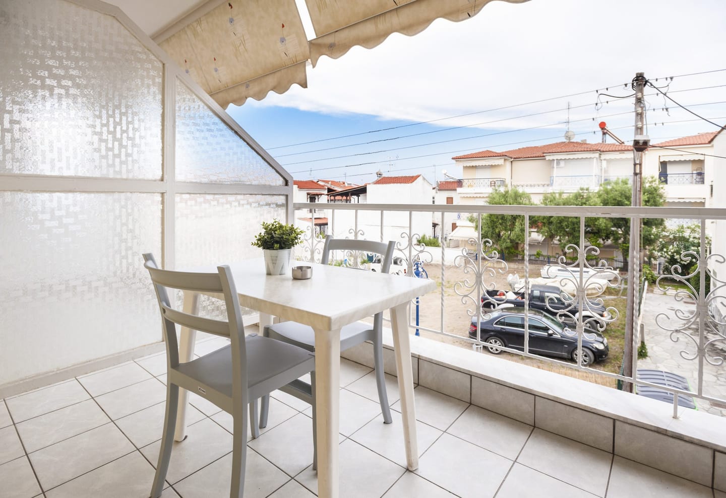 Balcony with table and partial sea view over the street