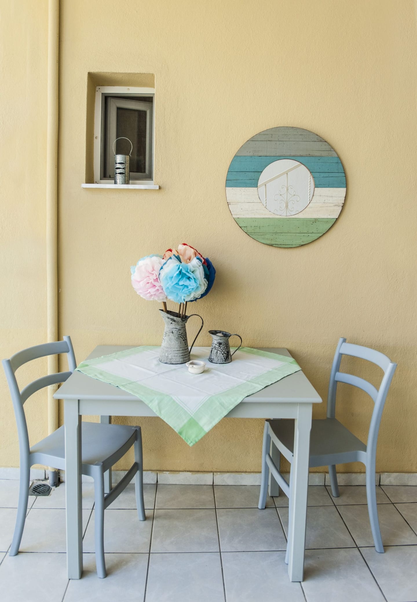 Yard table with flowers in front of the yellow wall